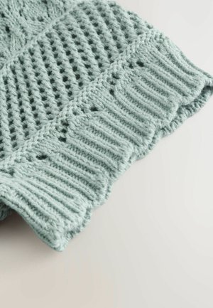 Tissu tricoté bleu clair avec des motifs ouverts, une texture côtelée et un bord festonné. Fabriqué à partir de fil doux pour le confort et la chaleur.