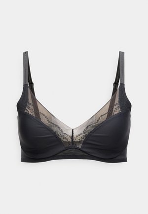 Soutien-gorge noir avec armatures, panneaux en mesh transparent ornés de dentelle florale, et bretelles réglables sur un fond clair.