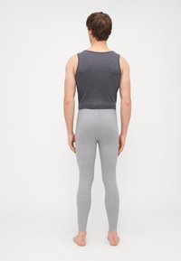 Szürke ujjatlan póló és világosszürke leggings, mindkettő puha, rugalmas anyagból, hátulról nézve. Nincsenek minták vagy kiegészítő díszítések.