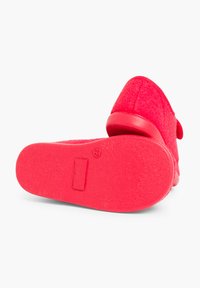 Scarpa slip-on rossa con upper testurizzato, tessuto morbido e suola in gomma liscia. Include un tacco piatto e dettagli minimi sulla parte superiore.