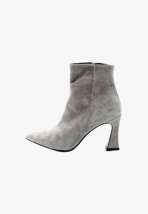 Bottine en daim gris clair avec un bout pointu et un talon épais et angulaire. Texture lisse avec une silhouette sans couture et une fermeture éclair.