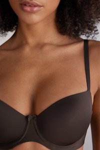 Hnědá vycpaná podprsenka s bezešvým designem, nastavitelnými ramínky a malou mašlí uprostřed. Hladká tkanina s matným povrchem.