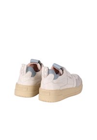 Sneakers in pelle bianca con dettagli blu, texture particolare e suola chunky beige. Presentano un anello sul tallone per indossarli facilmente.