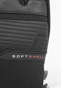 Guante de softshell negro con tejido texturizado, detalles de cuero y un logo rojo "SOFTSHELL". Presenta costuras reforzadas y un diseño aerodinámico.