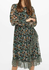 Bloemige jurk met lange doorzichtige mouwen, donkere achtergrond met groene, oranje en beige bloemen, ruches aan de onderkant, lichte stof.