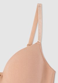 Seno beige con un design liscio e senza cuciture e spalline regolabili. Realizzato in tessuto morbido con una finitura opaca. Nessun motivo visibile o componenti metallici.