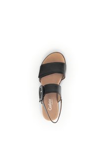 Zwarte leren sandalen met twee brede banden, verstelbare gesp en een tan voetbed. Platte zool met een gladde textuur, minimalistisch ontwerp.