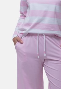 Maglietta a maniche lunghe a righe rosa e bianche con pantaloni rosa a vestibilità comoda, dotati di vita elastica e lacci. Tessuto in cotone morbido.