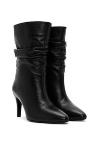 Bottines noires en cuir avec un bout pointu et un talon aiguille de 7,5 cm. Présente un design froncé au niveau de la cheville pour un aspect abandonné.
