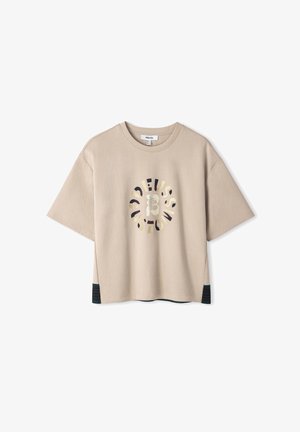 Beige T-shirt met korte mouwen en een oversized pasvorm, voorzien van een grafisch ontwerp in zwart en goud. Gevoerde zijpanelen in donkergroen.
