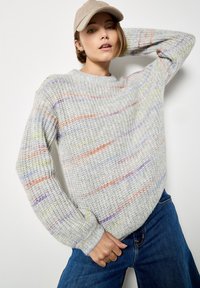 Maglione grigio chiaro a maglia grossa con strisce orizzontali multicolori in arancione, viola e verde. Collo rotondo e polsini a coste.