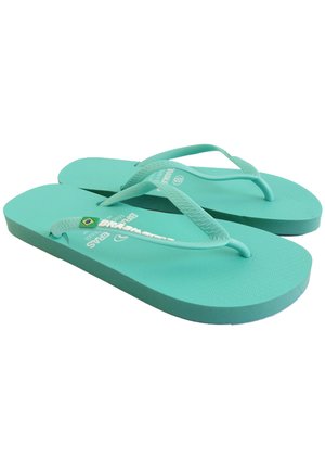 Chanclas turquesas con suelas texturizadas y tiras finas. Presentan un detalle de la bandera brasileña y un logo de la marca en relieve en las tiras.