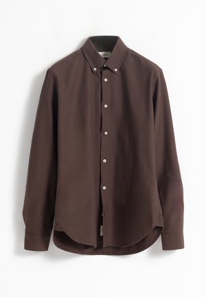 Camisa de manga larga marrón, hecha de tejido suave, con cuello abotonado, botones blancos y un dobladillo curvado.