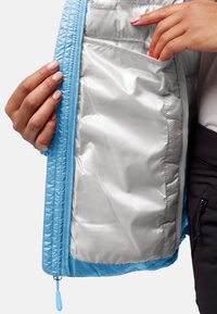 Lichtblauwe jas met een glanzend zilveren interieur, met een rits en binnenzakken. De stof lijkt glad en textuur te hebben.