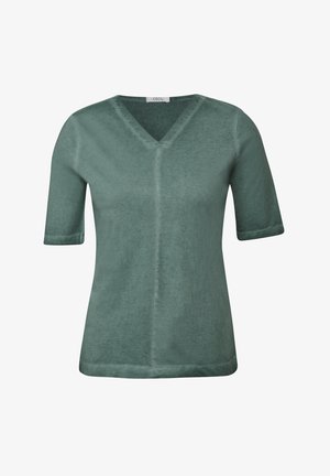 Vihreä lyhythihainen paita, jossa on V-pääntie. Valmistettu pehmeästä, teksturoidusta kankaasta, suoran leikkauksen ja näkyvien saumoilla. Merkkilogo näkyvissä.