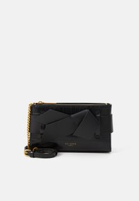 Clutch de couro preto com textura de crocodilo, apresentando um grande detalhe em fita preta mate e uma alça de corrente em tom dourado. Logo minimalista em relevo.