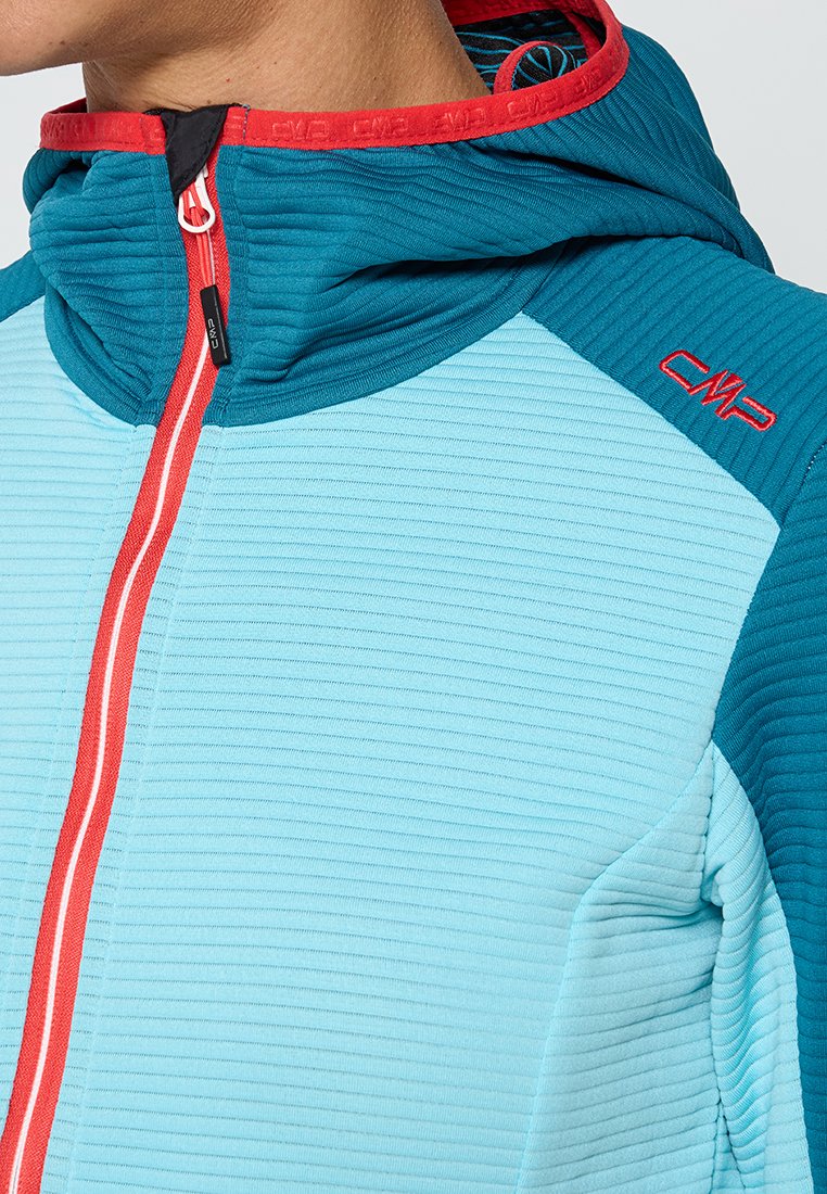 Veste à capuche en bleu clair et teal avec un tissu texturé. Présente une fermeture éclair et des accents rouges, avec un design côtelé sur les manches.