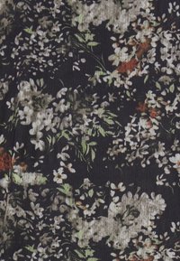 Tessuto scuro con un denso motivo floreale che presenta piccoli fiori bianchi, beige e rossi con foglie verdi.