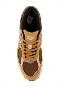 Baskets en maille et daim marron avec un bout renforcé, accents beiges, détails gris et logo orange. Équipées de lacets plats et d'un col rembourré.