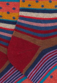 Multicolored socks featuring a mix of stripes and polka dots. Materials are soft, with prominent red, blue, pink, and yellow tones, creating distinct sections.