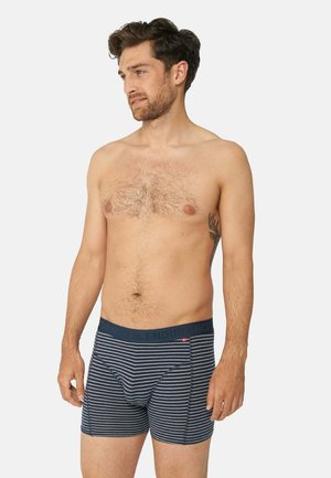 Námořnické a bílé pruhované pánské boxerky s logem na pasu. Tkanina vypadá měkce a má blízko přiléhající, elastický design.