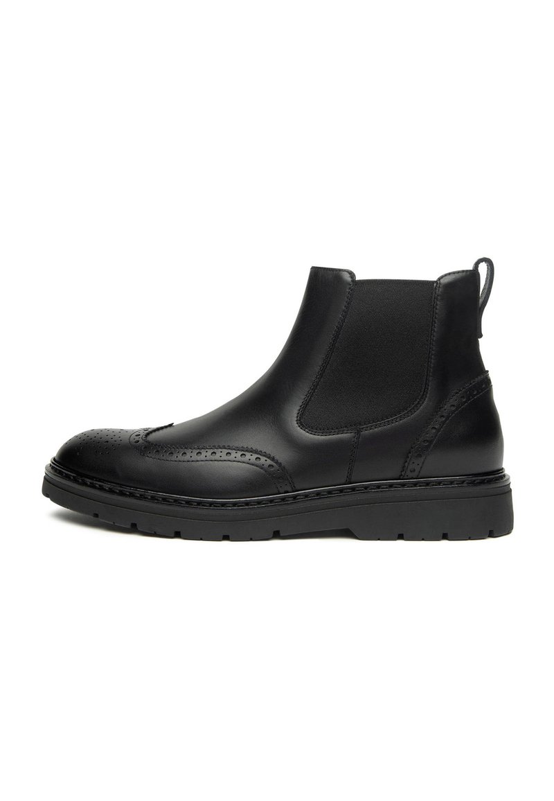 Bottes Chelsea en cuir noir avec des détails de brogue, des panneaux élastiques sur les côtés et une épaisse semelle en caoutchouc noir. Texture lisse, design à bout rond.