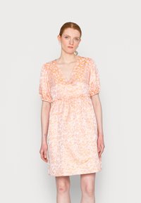 Vestido floral em rosa pastel com mangas bufantes, decote em V e cintura elástica. Apresenta um tecido leve e texturizado com padrões delicados.