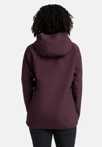 Veste imperméable bordeaux avec capuche, texture lisse, design ajusté et ourlet arrière légèrement plus long. Pas de logos ni de motifs visibles.