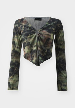 Langermet, cropped topp i grønn og svart camo mønster, med V-hals og knute detalj foran, laget av et strukturert stoff.
