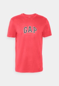 Camiseta de algodón roja de manga corta con cuello redondo y logo "GAP" en letras blancas y negras centrado en el pecho.