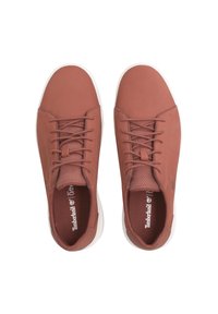 Un paio di sneakers Timberland marroni con suole bianche, lacci e linguetta in rete traspirante, viste dall'alto su uno sfondo bianco.