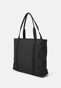Sac tote noir en nylon, doté de deux poignées tissées robustes, d'une forme rectangulaire et d'un design minimaliste sans quincaillerie ni motifs visibles.