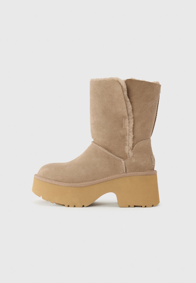 Beige suede laarzen tot halverwege het kalf met een dikke gele plateauzool, voorzien van een zachte, gestructureerde voering en een ronde neus. Eenvoudige buitenkant.