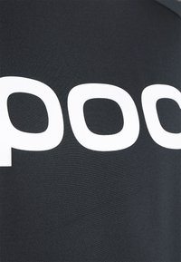 Svart tyg med en slät textur som har stora vita bokstäver som står "pood." Designen fokuserar på djärv kontrast.