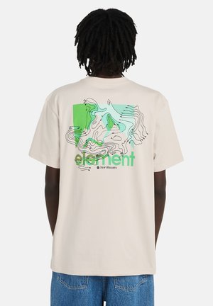 T-shirt beige chiaro in cotone, con un design grafico astratto verde e blu sul retro con linee ondulate e testo.