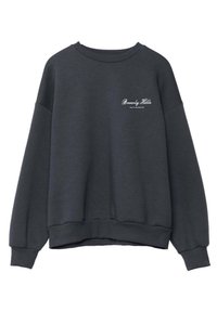 Sudadera gris oscuro con cuello redondo acanalado, corte holgado y hombros caídos. Presenta el texto en blanco "Beverly Hills" en la parte delantera.