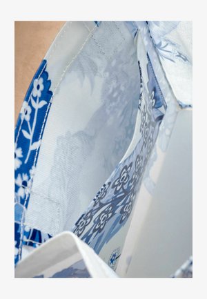 Niebiesko-białe tkaniny w kwiatowy wzór o miękkiej fakturze, z wewnętrznymi kieszeniami i lekkim, przewiewnym fasonie.