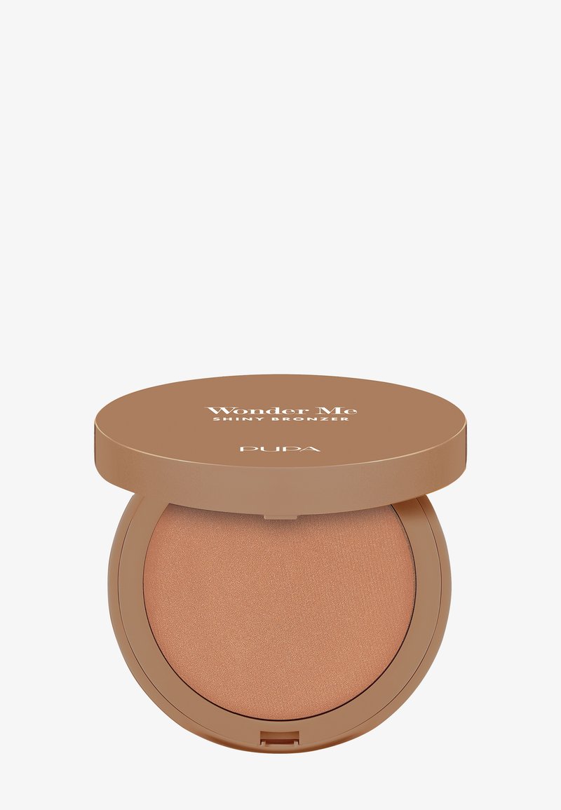 Bronceador con acabado brillante en un compacto redondo. Tono marrón claro con un brillo sutil. El envase presenta una tapa sólida color tostado y marca visible.