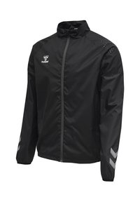 Schwarze leichte Sportjacke mit durchgehendem Frontreißverschluss, hohem Kragen, Hummel-Logo auf der Brust und reflektierenden Chevron-Streifen auf den Ärmeln.