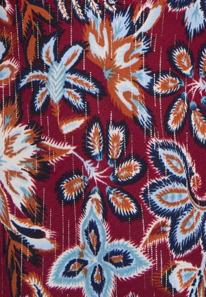 Tessuto rosso con un motivo floreale in blu, arancione e nero. Il design presenta petali texturizzati e strisce metalliche verticali.