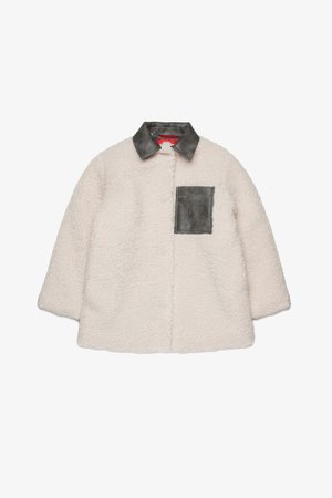 Casaco de shearling forrado em creme com colarinho de couro cinza e bolso no peito. Apresenta um exterior suave e texturizado e um corte descontraído.