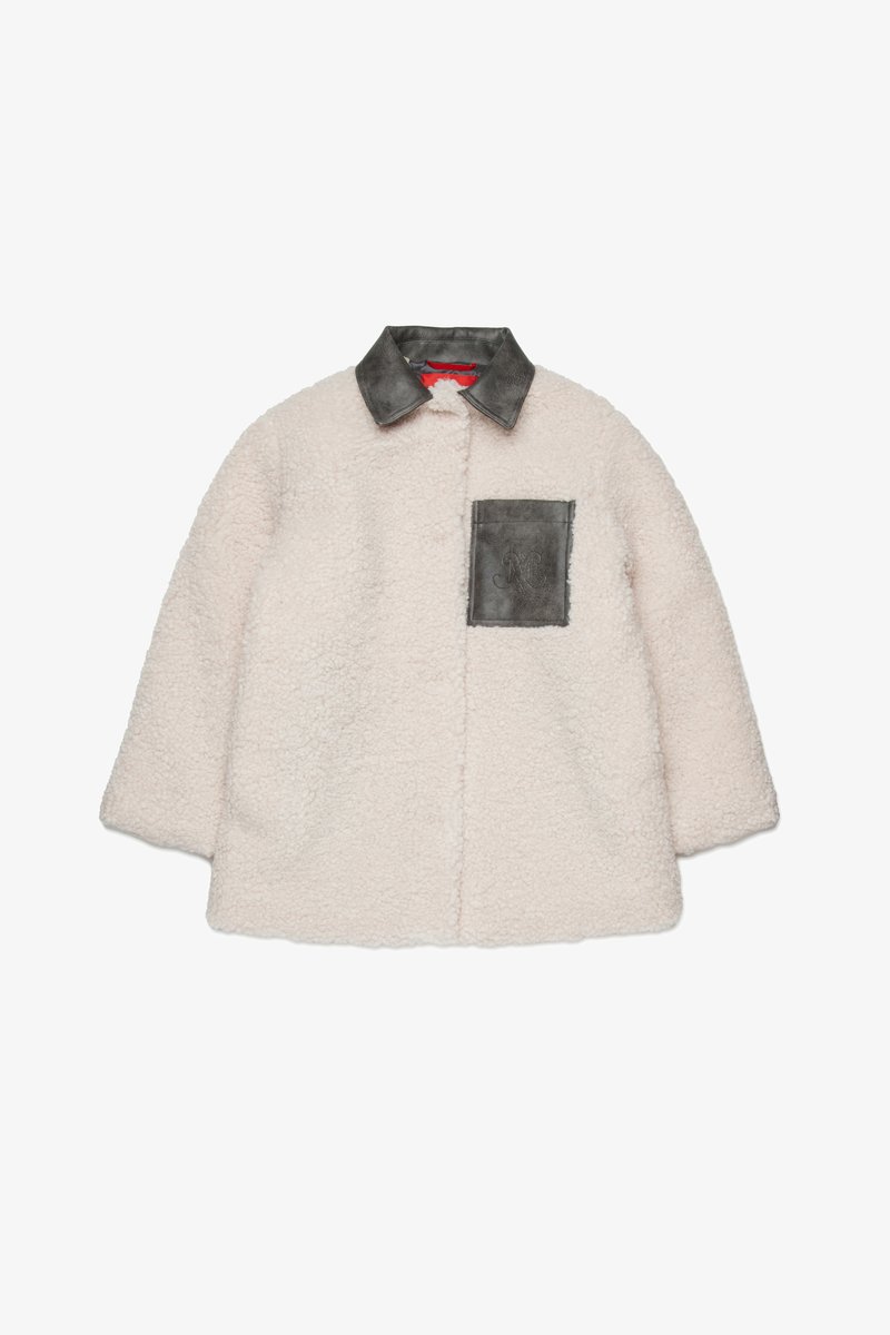 Veste en shearling crémée, doublée, avec un col en cuir gris et une poche poitrine. Elle présente un extérieur doux et texturé ainsi qu'une coupe décontractée.