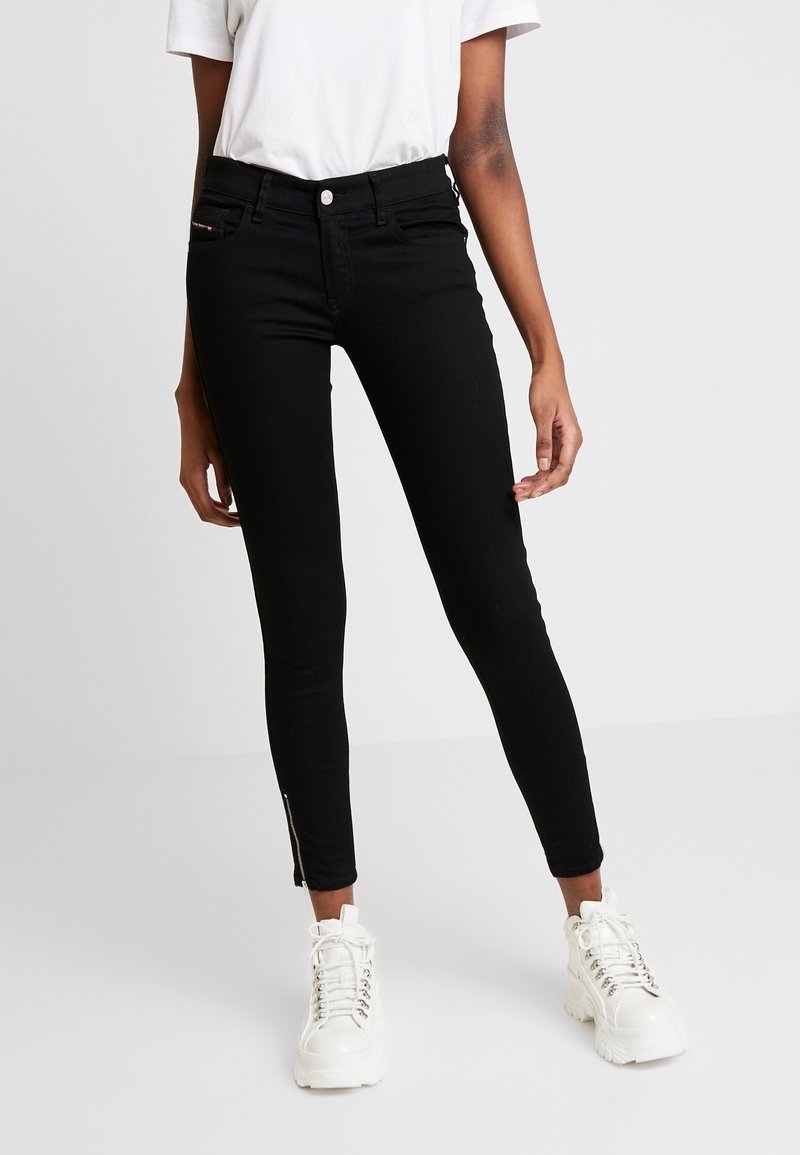 Černé skinny džíny s vysokým pasem, detaily na zip na kotnících a klasickým designem pěti kapes, vyrobené z denimové látky.