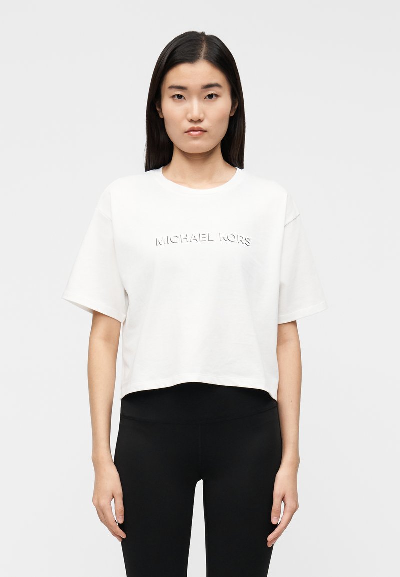 T-shirt branca cropped feita de algodão, com logótipo "MICHAEL KORS" em relevo na frente. Mangas curtas e corte descontraído.