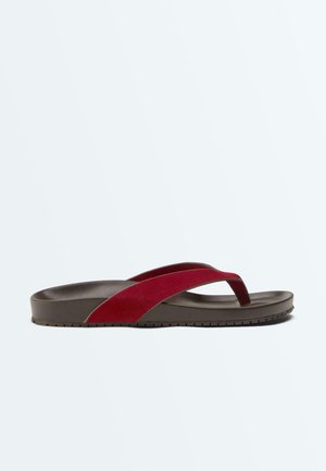 Žabky s tmavě hnědou podrážkou a tmavě červenými textilními pásky, boční pohled na jednobarevném světlém pozadí.