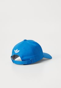 Kék pamut baseball sapka ívelt ernyővel, állítható pánttal, és fehér adidas trefoil logóval a hátulján. Sima textúra az egész felületen.