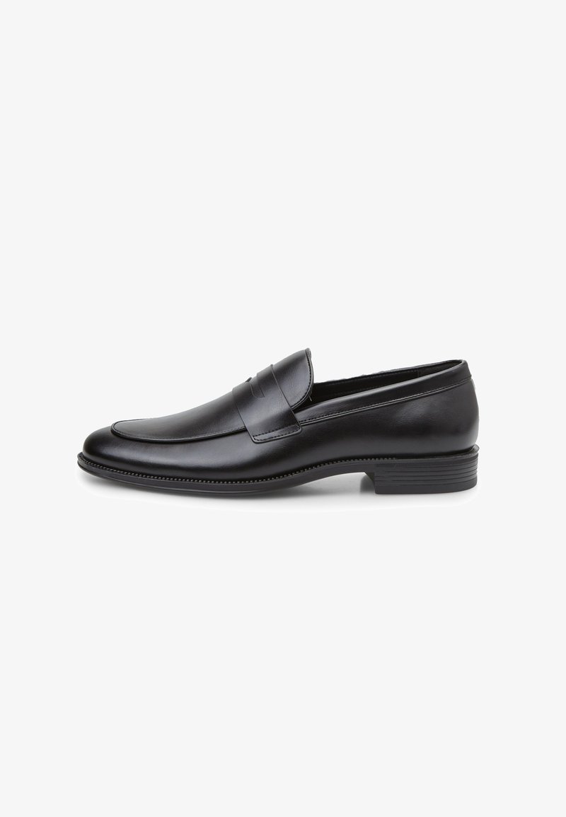 Zwarte leren loafer met een gebogen silhouet, gestikte details langs de rand en een platte rubberen zool voor grip.