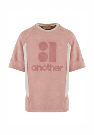 Tricou oversized, roz, cu mânecă scurtă, cu o textură asemănătoare pielii de iarbă. Prezintă panouri laterale crem contrastante și un design mare imprimat în centru.