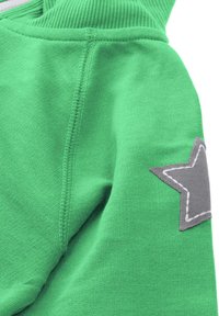 Green sweatshirt featuring a textured fabric, with a grey star applique on the left sleeve, and ribbed cuffs and neckline.
