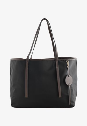 Zwarte tote tas met donkerbruine handvatten en afwerking, met een ronde leren hanger bevestigd met een gouden gesp aan de rechterkant.